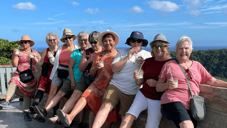 "A group of women over 50 enjoying an adventurous outdoor tour with drinks, smiling and bonding in a scenic setting."