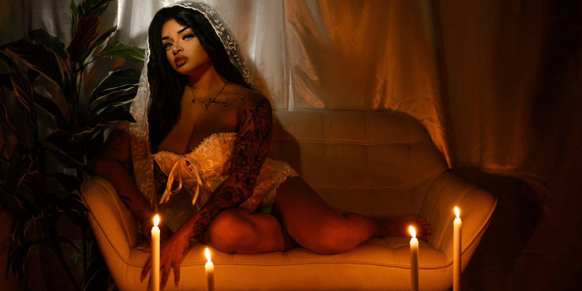 "Anastasia Artemiou seated in a soft, mystical setting, representing her spiritual brand The Manifestation Doll focused on magick, healing, and mindset work."