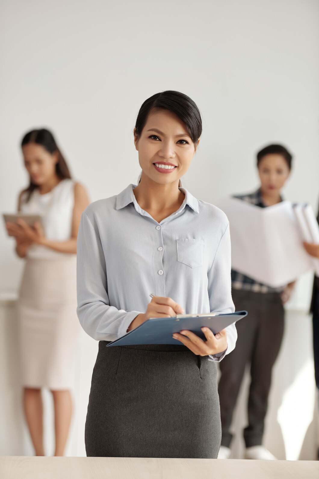 Asian Woman Smart Clothes Posing Studio With Clipboard Colleagues Background 1098 17386