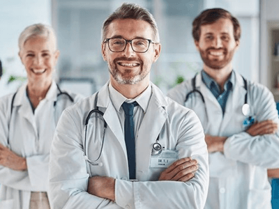 A diverse group of five healthcare professionals smiling confidently in a hospital setting