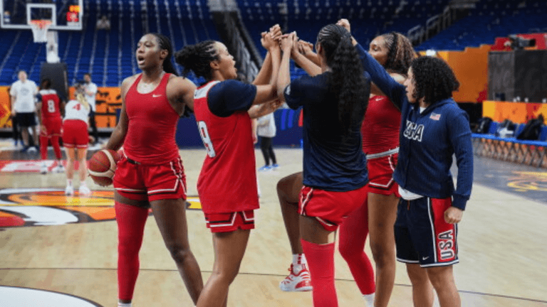 Female basketball players celebrating together on the court during practice session