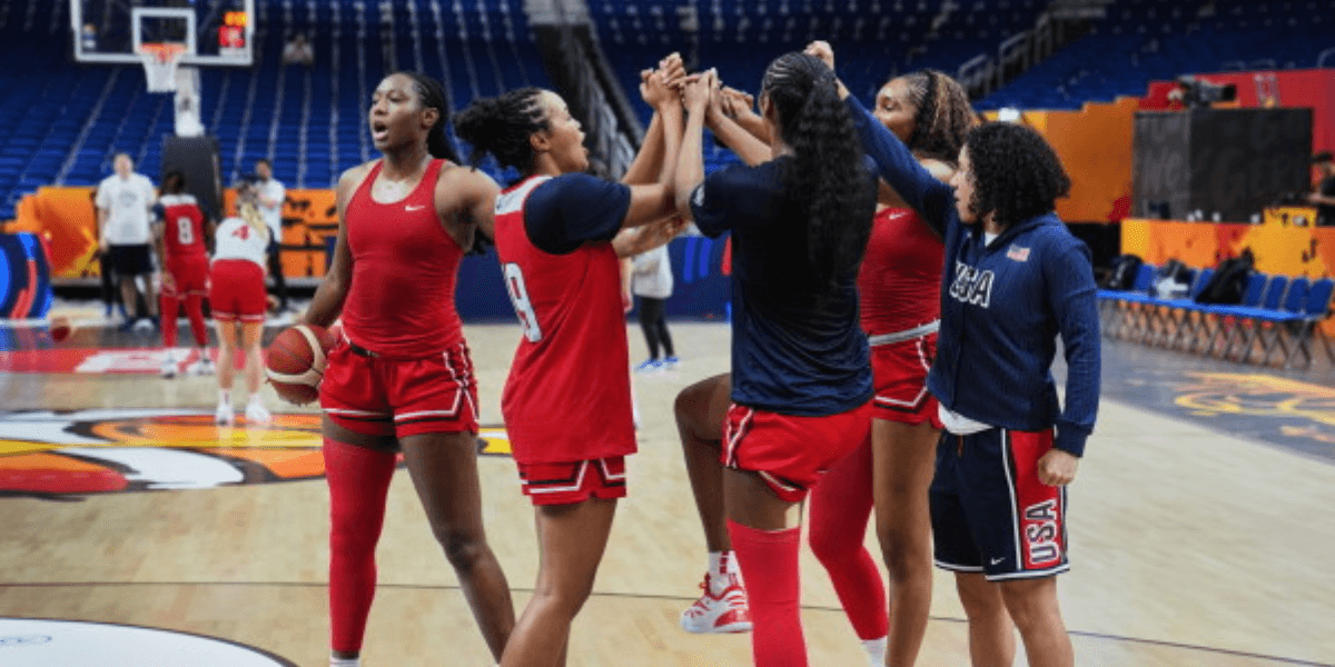 Female basketball players celebrating together on the court during practice session