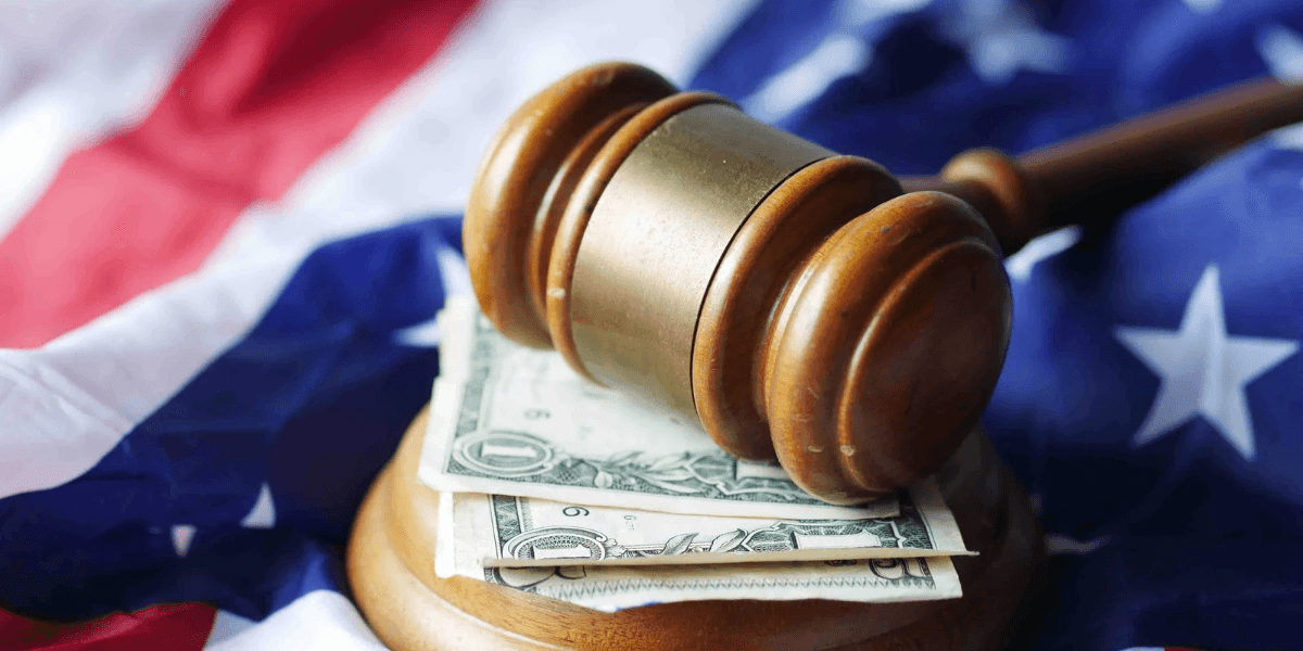 Gavel resting on dollar bills atop a folded American flag