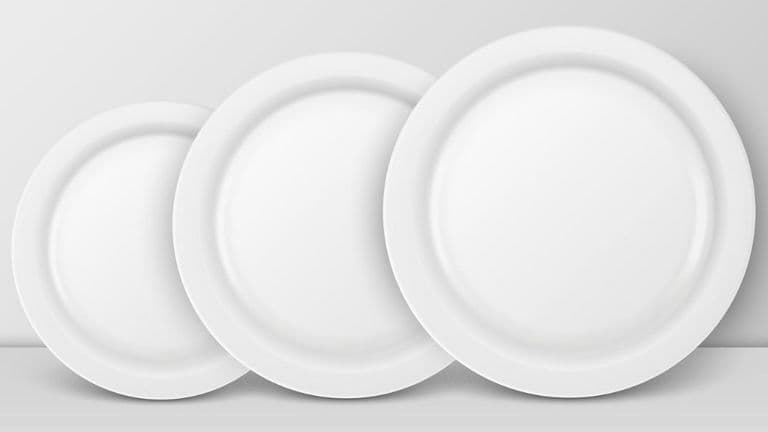 Three white plates of varying sizes stacked, symbolizing the concept of choosing a smaller plate for better alignment.