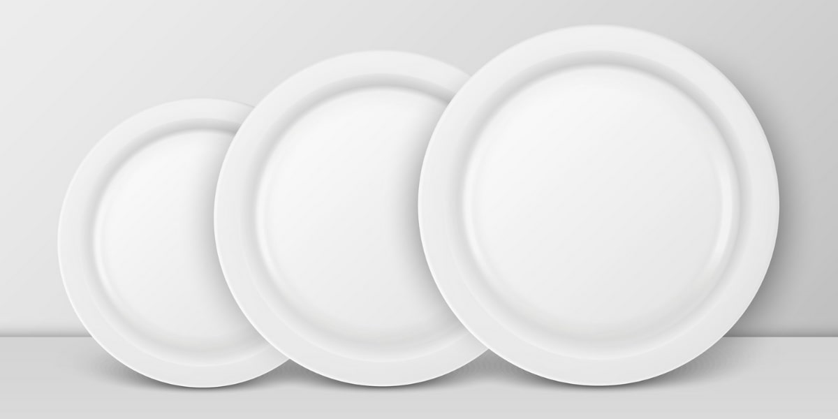 Three white plates of varying sizes stacked, symbolizing the concept of choosing a smaller plate for better alignment.