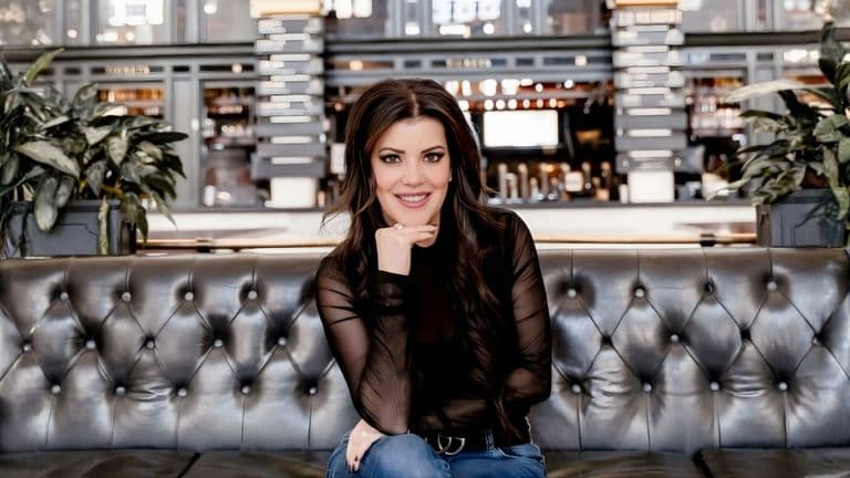 Maria Gallucci, advocate for inclusive communication, smiling while sitting on a couch, with a focus on accessibility.