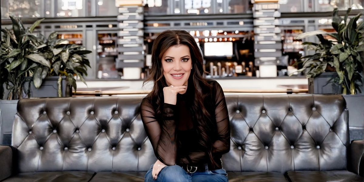 Maria Gallucci, advocate for inclusive communication, smiling while sitting on a couch, with a focus on accessibility.
