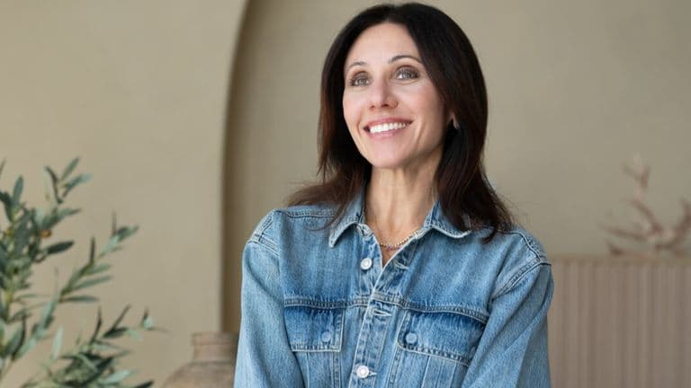A smiling woman in a denim jacket, embodying confidence and empowerment in midlife wellness.