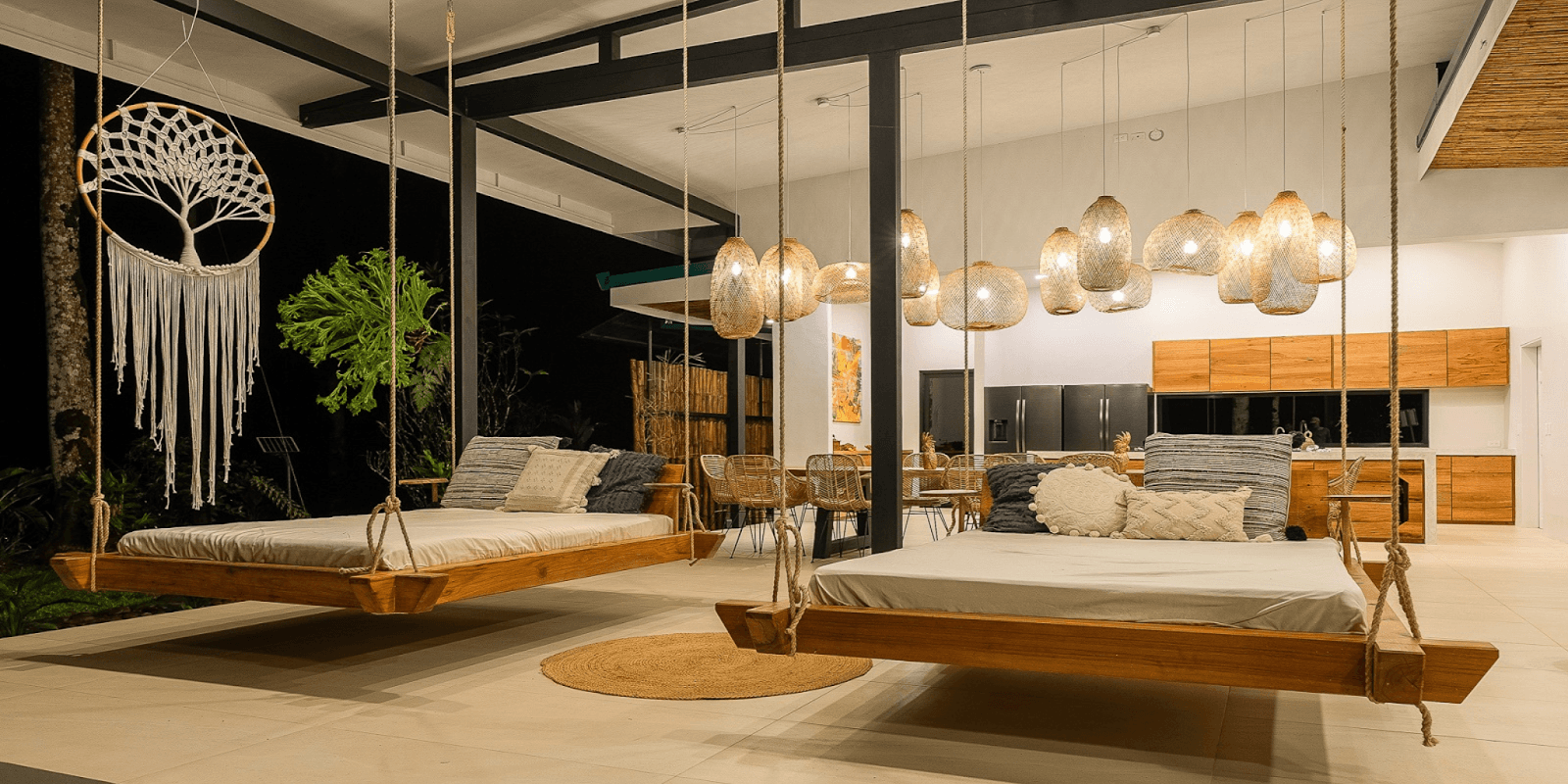 A serene wellness retreat featuring wooden swing beds, hanging lights, and nature-inspired decor, blending Pilates and nature immersion.