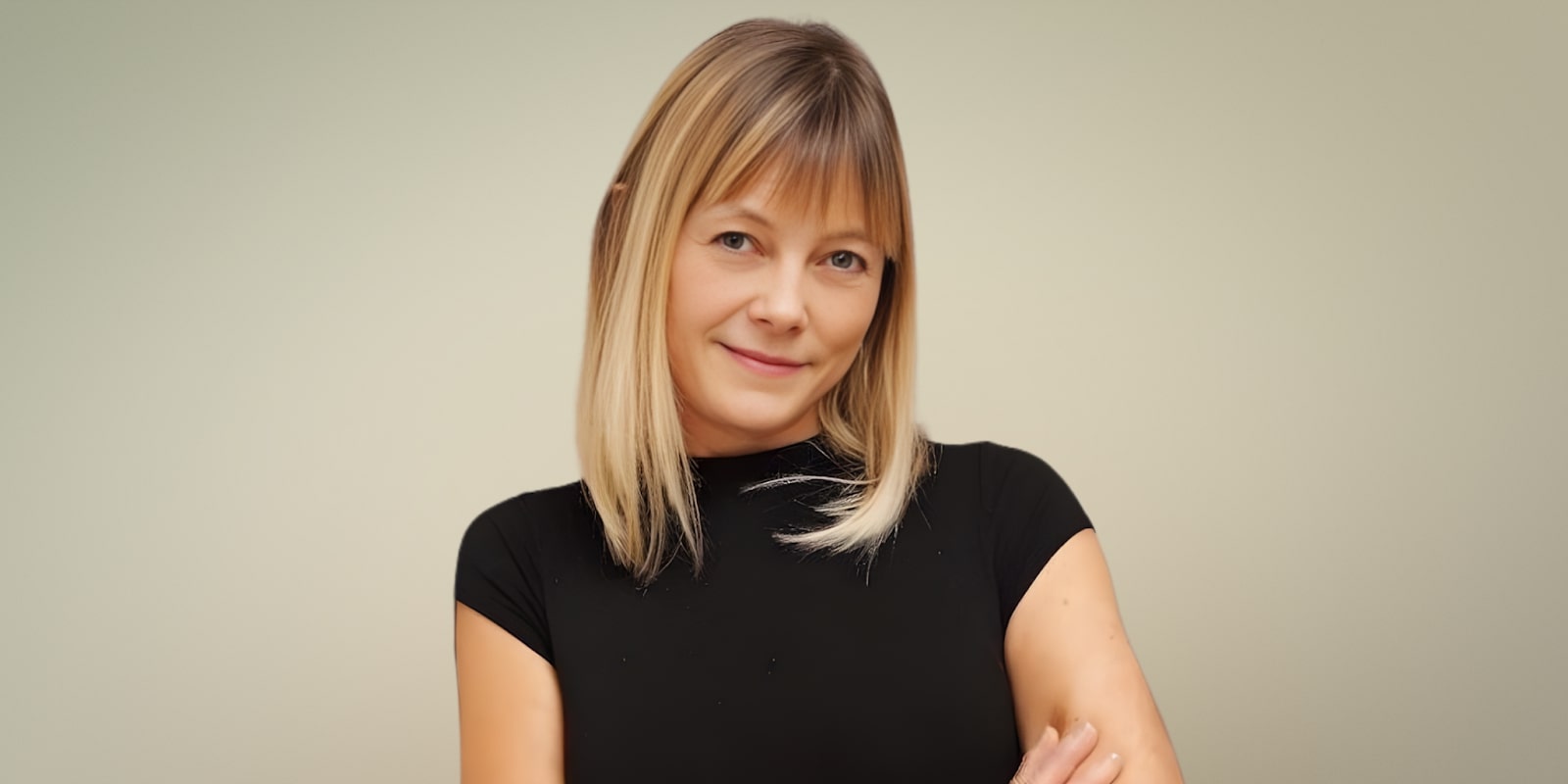 Kori Burkholder, career clarity coach, smiling confidently in a black shirt, with a neutral background, embodying empowerment.