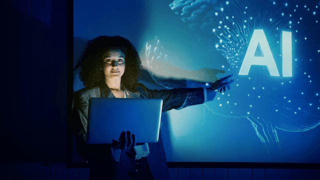 Professional holding a laptop while presenting AI concepts on a digital display.