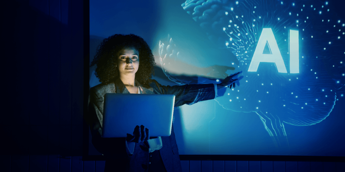 Professional holding a laptop while presenting AI concepts on a digital display.