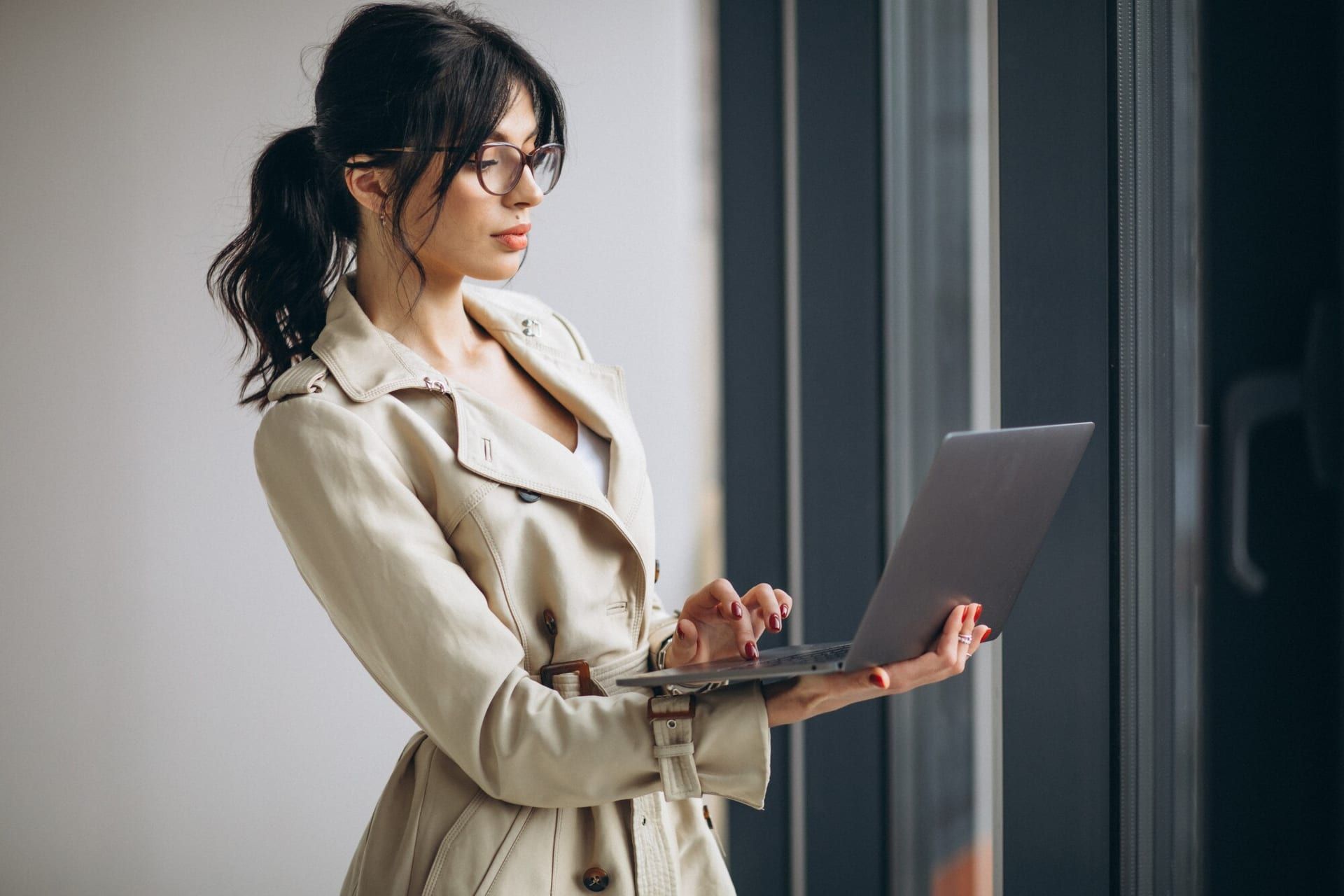 Young Business Woman With Laptop Standing By Window Office 1303 20570