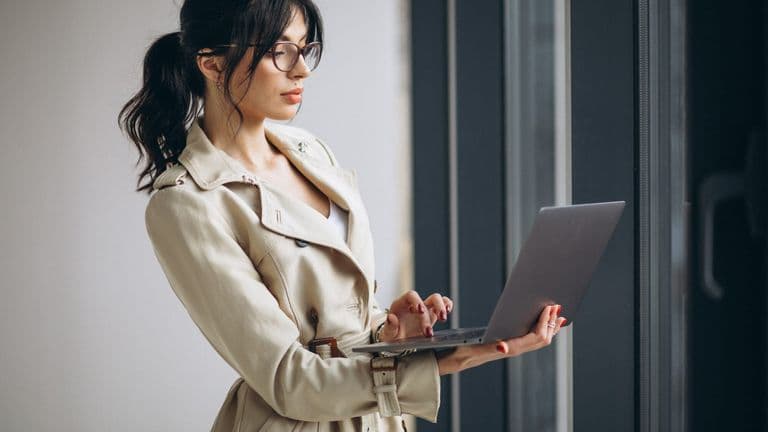 Young Business Woman With Laptop Standing By Window Office 1303 20570